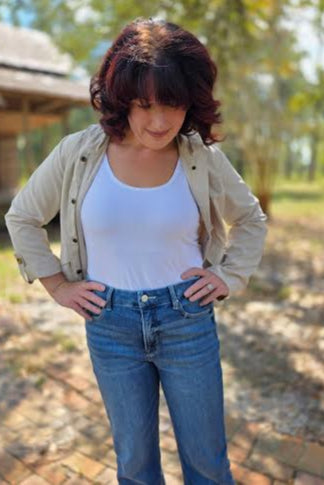 Woman wearing a cream snap button zip-up hoodie with front pockets, styled with denim jeans outdoors.